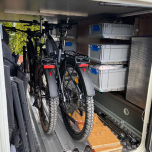 Beidseitig montierte youRS Regalsysteme mit Euroboxen und zentral positioniertem Fahrradhalter in der Heckgarage des Carthago C-Tourer.