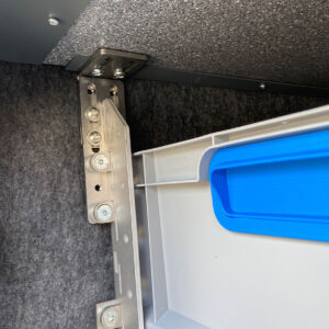 Detailansicht der hochwertigen Edelstahlwinkel-Montage des youRS Regalsystems in der Wohnmobil-Heckgarage.