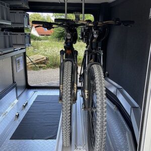 Zwei Fahrräder vor einem Regalsystem in der Heckgarage eines Concorde Wohnmobils.
