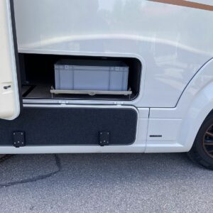 Unter dem Regalsystem montierte Auffahrschiene in der Heckgarage eines Wohnmobils.